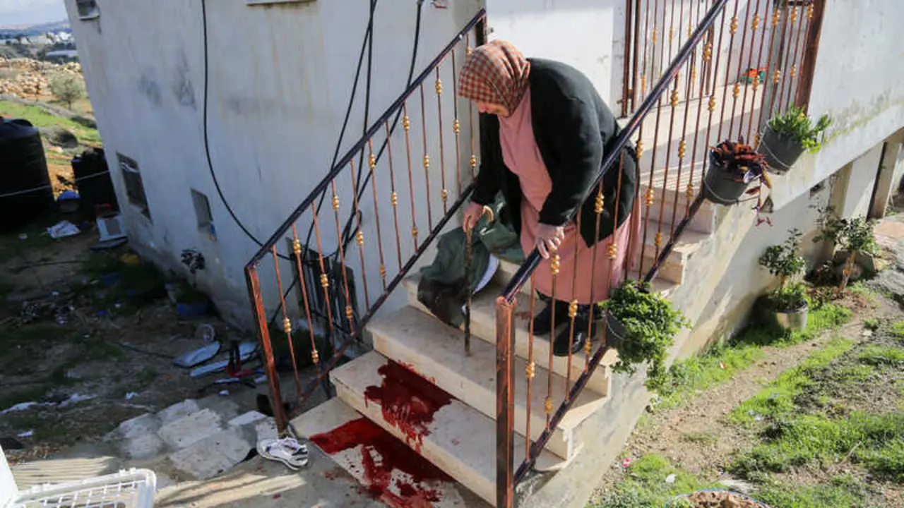 Fawzia al-Fasfous observa las manchas de sangre en los escalones de su casa despu&eacute;s de que su hijo Khaled al-Fasfous, de 38 a&ntilde;os, fuera tiroteado por las fuerzas terroristas israel&iacute;es durante su detenci&oacute;n en Dura, localidad cercana a la ciudad de Hebr&oacute;n, en el sur de Cisjordania, 15 de enero de 2026 - Mosab Shawer / ActiveStills.